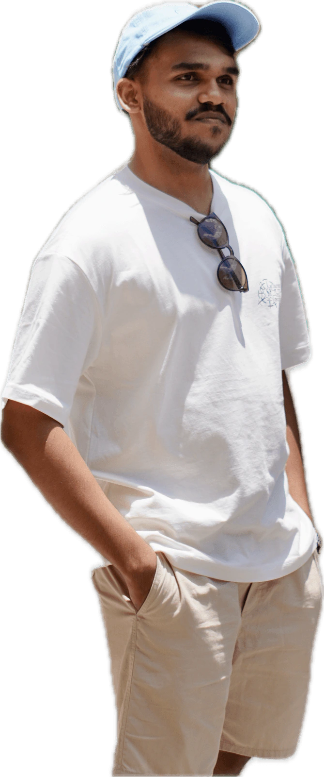 Harish standing in a white tee and cap
